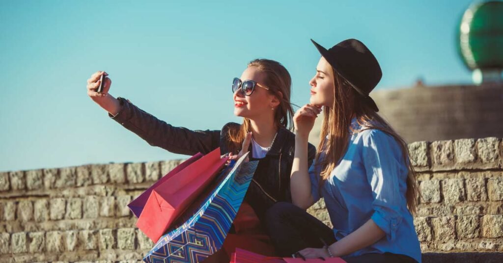 dos chicas tomandose una foto con sus compras
